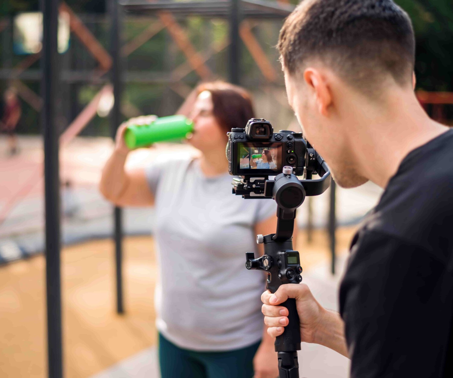 fotografo inquadra donna che beve mentre fa sport